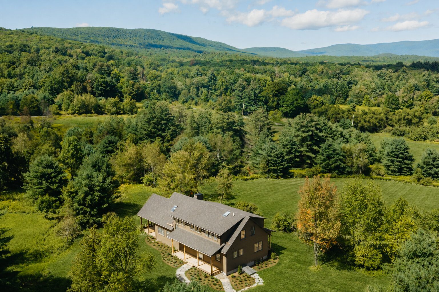 Hemlock House — aerial view of the house in its meadow with the Catskill ridge beyond