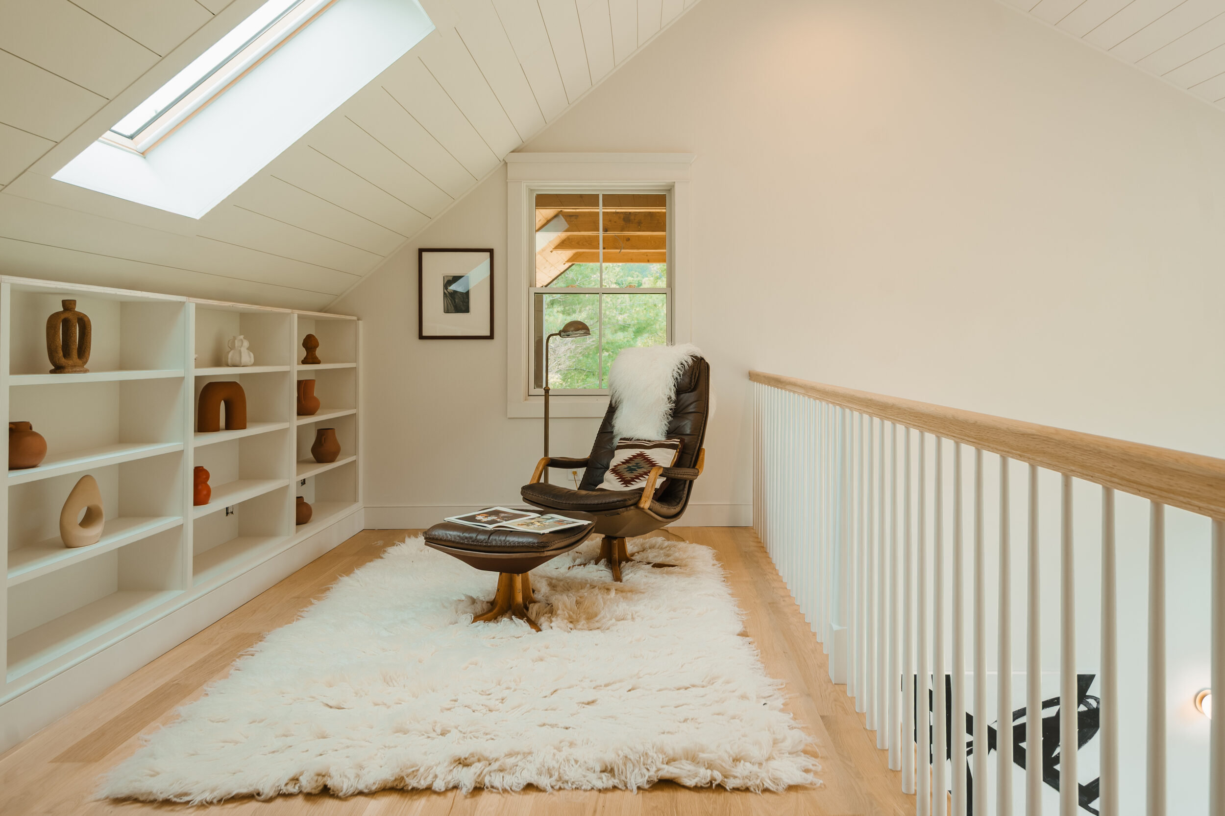 Hemlock House — mezzanine library with built-in shelving and skylight