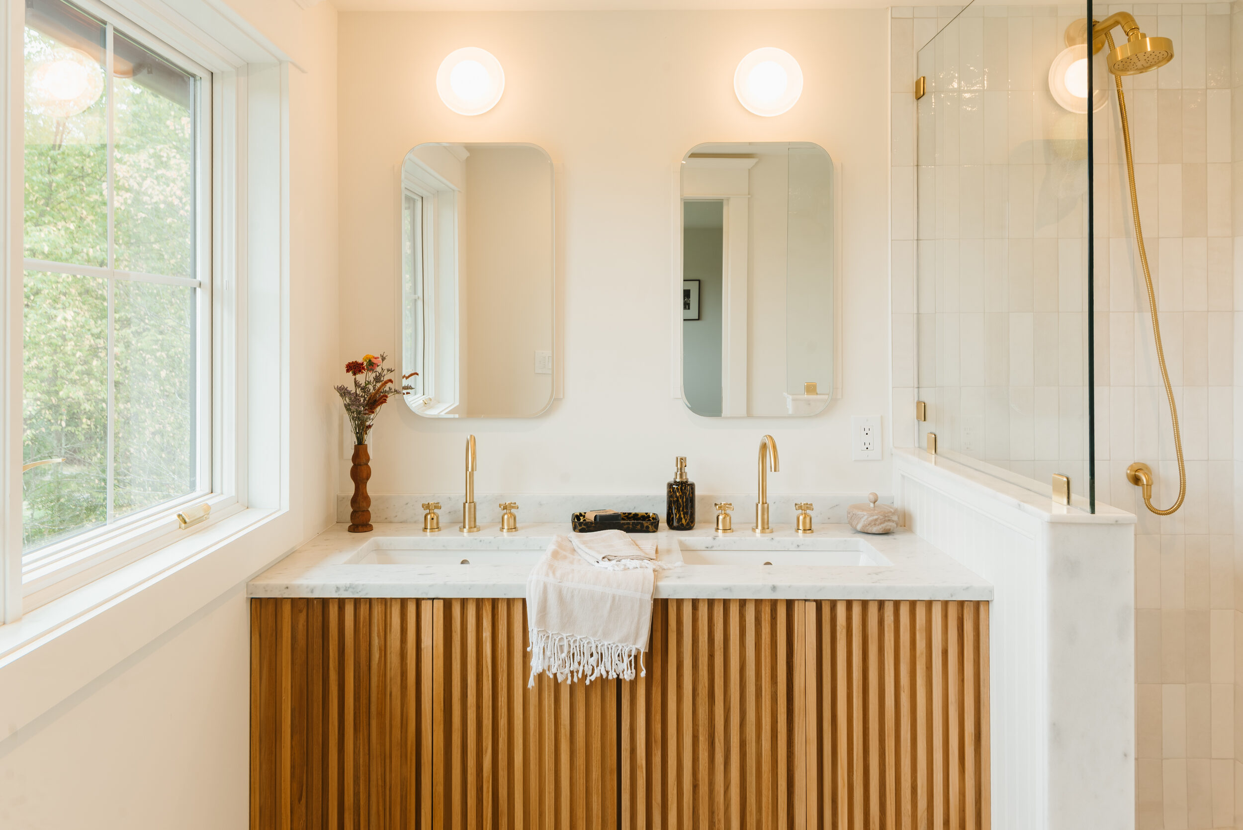 Hemlock House — primary bath with fluted oak vanity and brass fixtures